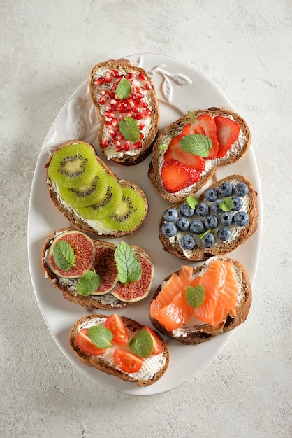 Vegetarian sandwiches from rye bread with soft cheese, and fruits