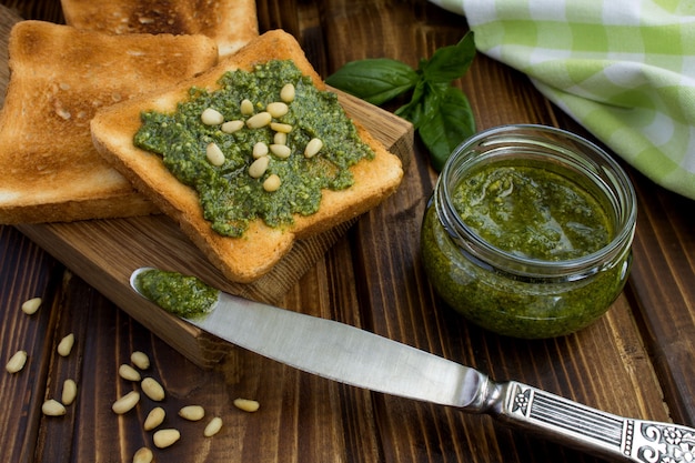 Vegetarian sandwiches  with sauce pesto and pine nuts  on the wooden cutting board