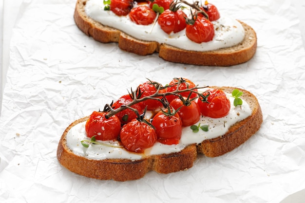 Vegetarian sandwiches with whole grain bread Toast sandwiches with ricotta cheese and baked tomatoes