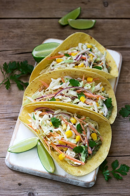 Vegetarian tacos stuffed with cabbage salad on wood