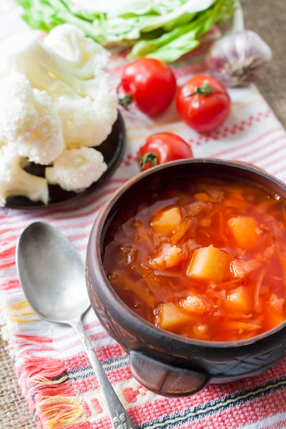 Vegetarian tomato soup with cabbage and cauliflower in a ceramic rustic bowl