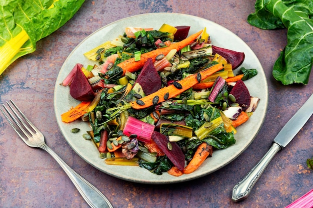 Insalata tiepida vegetariana di verdure stufate e foglie di bietola