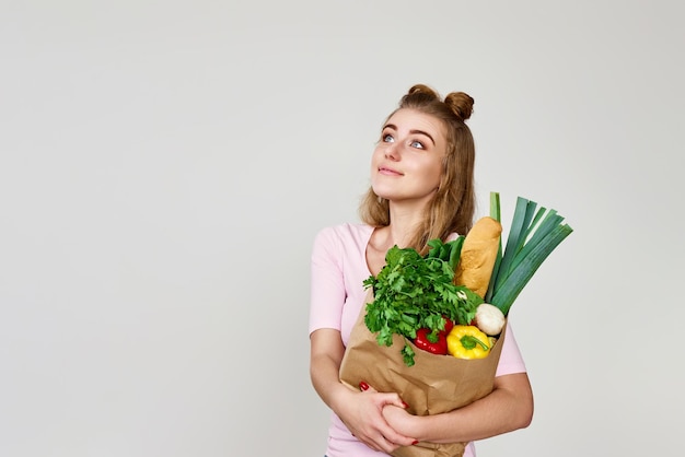 菜食主義者の女性が野菜を持った紙袋を握っている