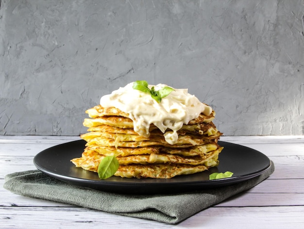 Vegetarian zucchini pancakes with basil leaves on a plate The concept of healthy food