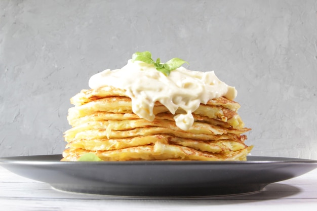 Vegetarian zucchini pancakes with basil leaves on a plate The concept of healthy food