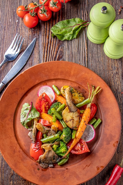 Vegetarisch eten, bijgerecht van gebakken groenten en champignons, restaurant gerecht, verticale oriëntatie, bovenaanzicht