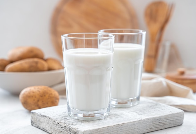 Vegetarische aardappelmelk in twee glazen op een lichte close-up als achtergrond Plantaardige melk