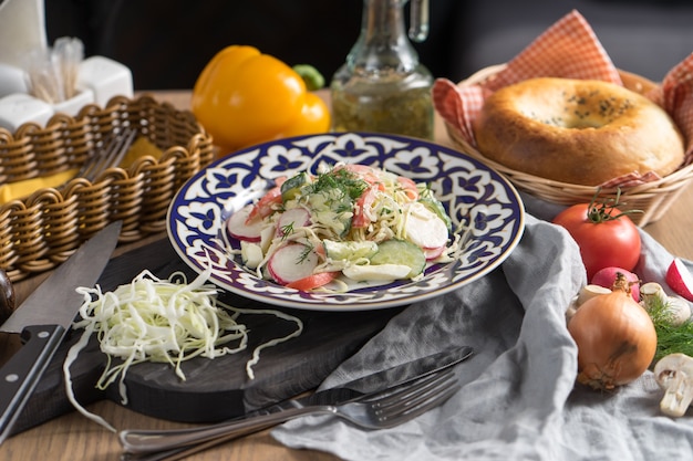 Vegetarische groentesalade van radijs en zure room in een plaat met traditioneel Oezbeeks