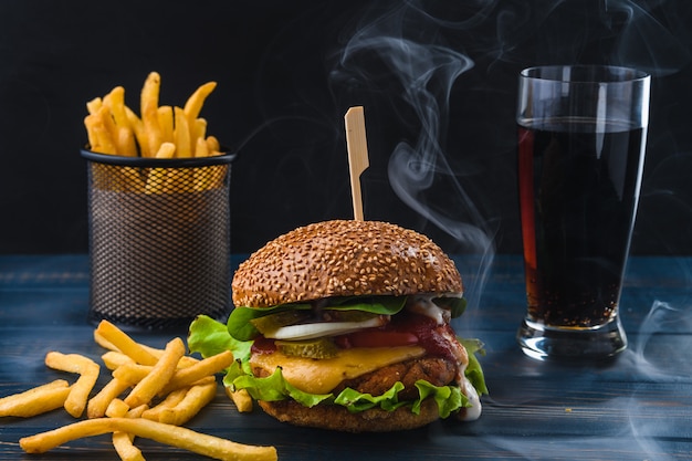 Vegetarische Hamburger met friet en drank op houten tafel