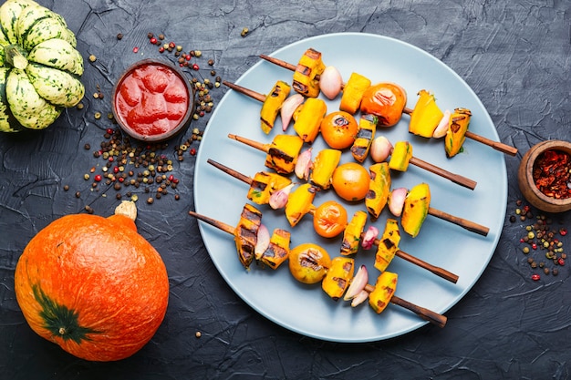 Vegetarische heerlijke pompoen en tomaat sjasliek. Pompoen gebakken op spiesjes.