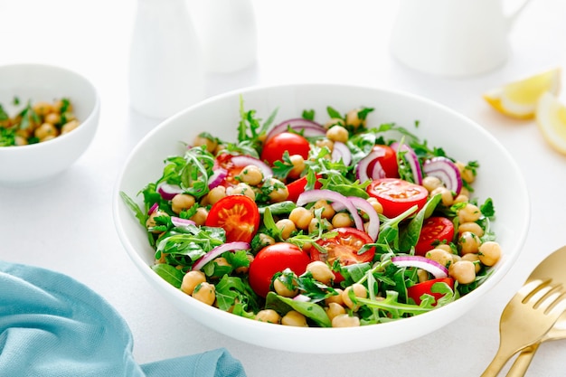 Vegetarische kikkererwtensalade met tomaten, rucola, peterselie, spinazie en rode ui Gezond voedseldieet