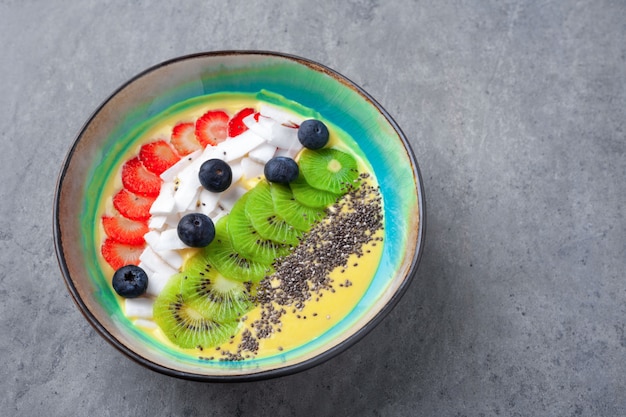 Vegetarische mango smoothie bowl met kiwi, chia, kokos, bosbes, aardbei