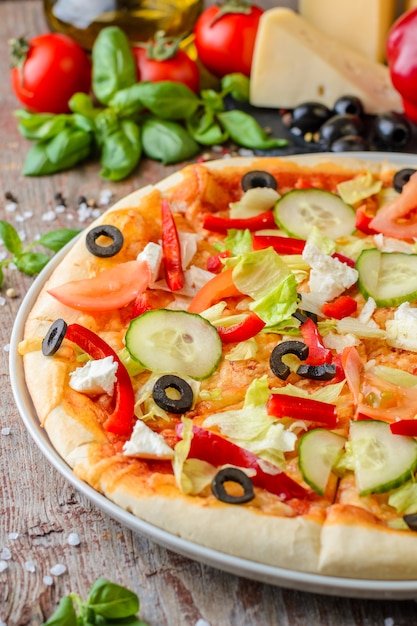 Vegetarische pizza met groenten en ingrediënten op een hout