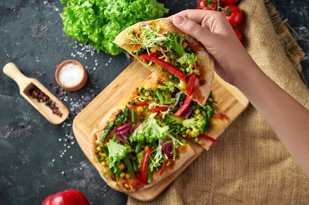 Vegetarische pizza met groenten en saus op een bord Donkere achtergrond