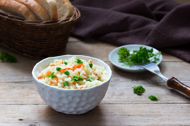 Vegetarische rijstgerecht met groenten en groene erwten op een houten oppervlak