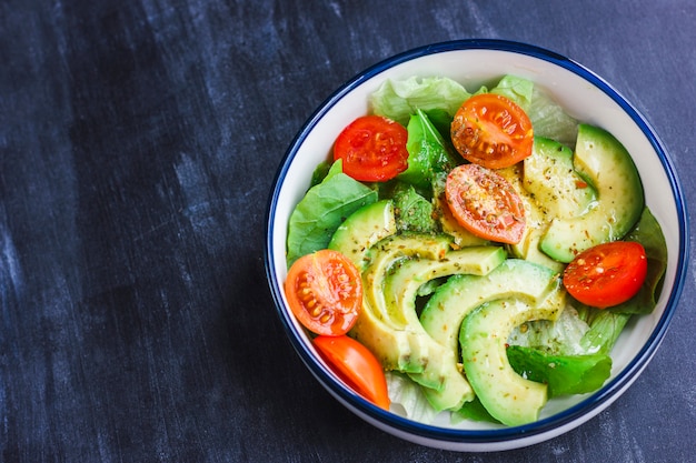 Vegetarische salade met avocado, rucola, kerstomaatjes en kruiden.