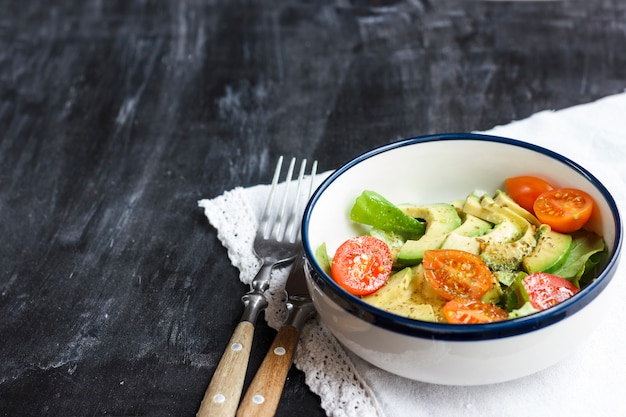 Vegetarische salade met avocado, rucola, kerstomaatjes en kruiden.