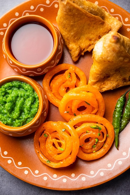 Foto vegetarische samosa met jalebi snackcombinatie ook wel imarti en sambusa samusa genoemd