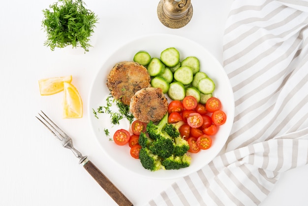 Vegetarische schotel van aardappelpasteitjes met kruiden en groenten op een plaat