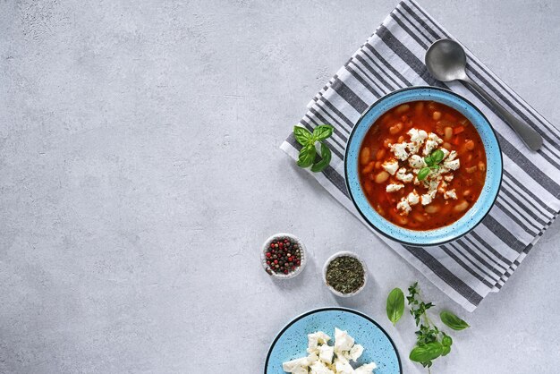 Vegetarische soep met witte bonen en groenten op lichte achtergrond bovenaanzicht kopie ruimte