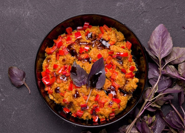 Vegetarische soja vleesgerecht met basilicum en peper op een zwarte achtergrond.