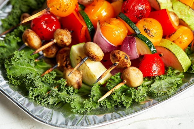 Vegetarische spiesjes met droge kruiden op houten spiesjes van courgette tomaat ui champignons op een bord