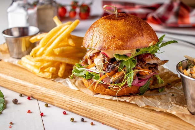 Vegetarische verse burger met champignons en groenten geserveerd met frietjes op een houten plank