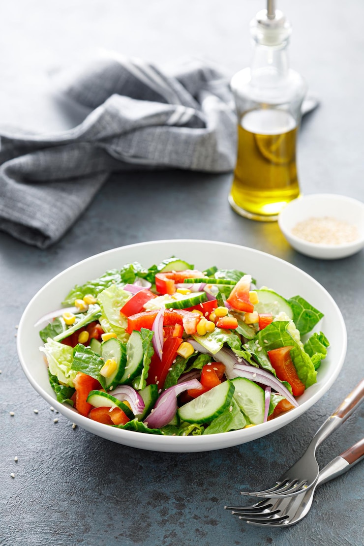 Foto vegetarische verse groente biologische salade met komkommer rode paprika rode ui mais en groene sla