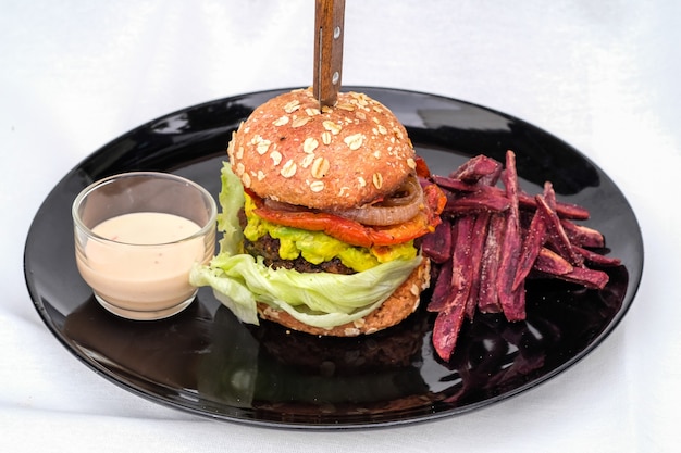 Foto hamburger vegetariano e vegano con grano saraceno, pomodoro, cipolla, maionese vegana e spinaci su un panino fresco