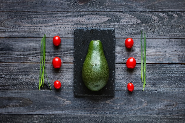 Veggie Voedselsamenstelling met halve avocado over een donkerachtige