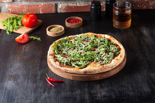 Vegitarian Pizza Fresh homemade pizza with arugula and chilli on rustic wooden background wirh ingredients