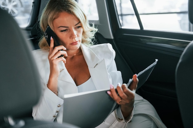 Vehicle interior Woman in formal clothes is indoors in the autosalon