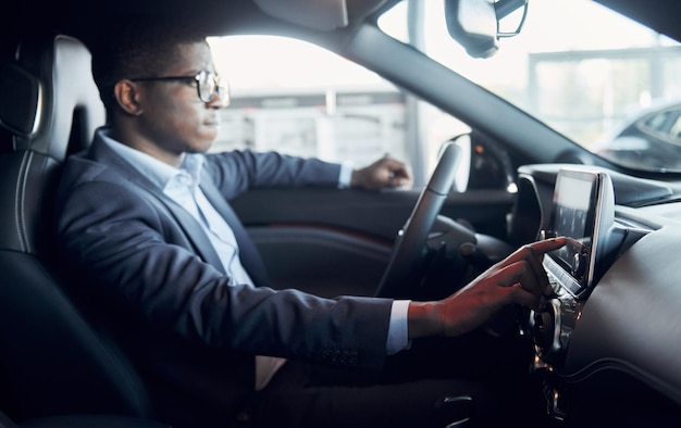 Vehicle interior Young african american businessman in black suit is in the automobile