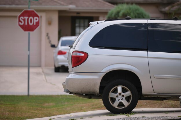 Photo vehicle parked in front of wide garage double door on paved driveway of typical contemporary american home