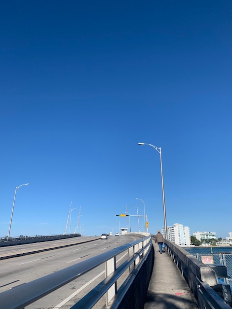 Vehicles on road against clear blue sky