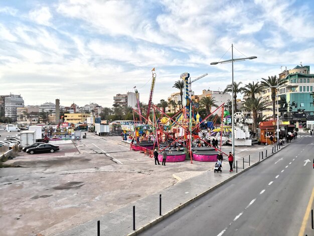 Vehicles on road against sky in city