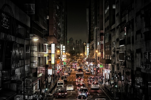 Vehicles on road along buildings at night