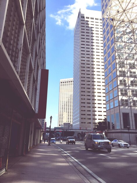 Vehicles on road amidst modern buildings