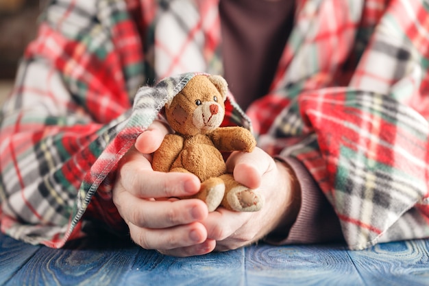 Veilig concept voor kind, mannelijke hand houden speelgoed beer