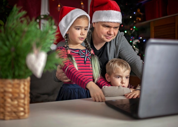 Veilige online kerst gelukkige familie in rode kerstmutsen die virtueel via internet vieren