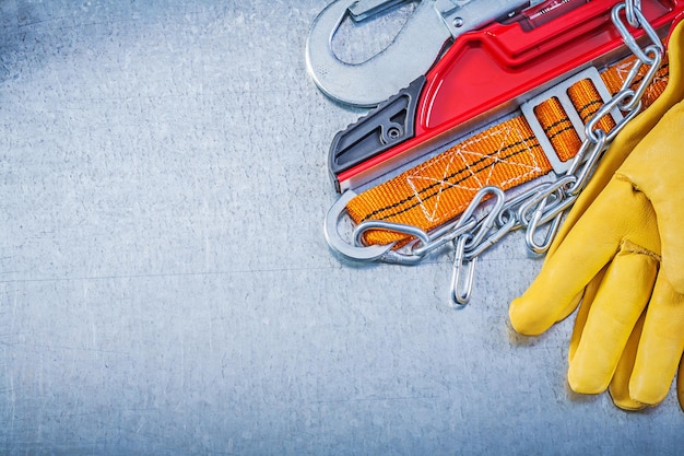 Veiligheidsgordel beschermende handschoenen constructieniveau op metalen achtergrond