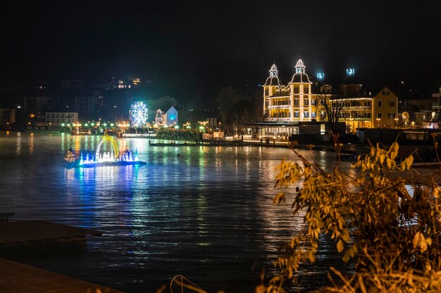 Photo velden reflections on the water and christmas atmosphere advent wreath and floating crib austria