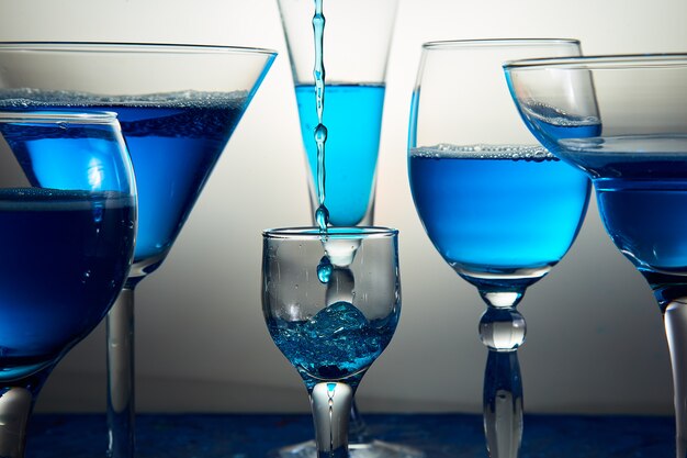 Vele glazen met blauwe champagne of cocktail.