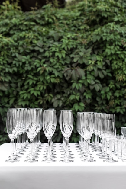 Vele lege schone glazen voor gasten bij de lijst van het buffet feestelijke huwelijk