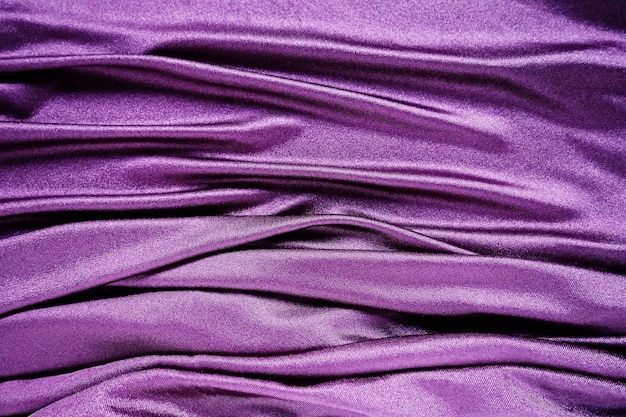 Velour fabric similar to silk Textiles in a folds and beautiful waves Purple pink magenta shades on the drapery Sewing material for evening dresses furniture upholstery curtains and interior