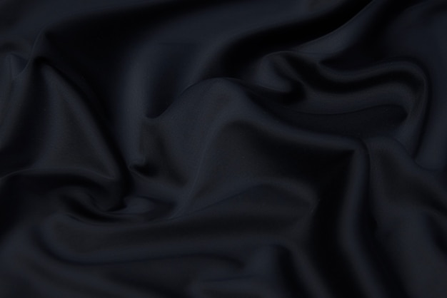 Velvet silk or cotton or wool fabric tissue. Dark gray or black color. Texture, background, pattern.