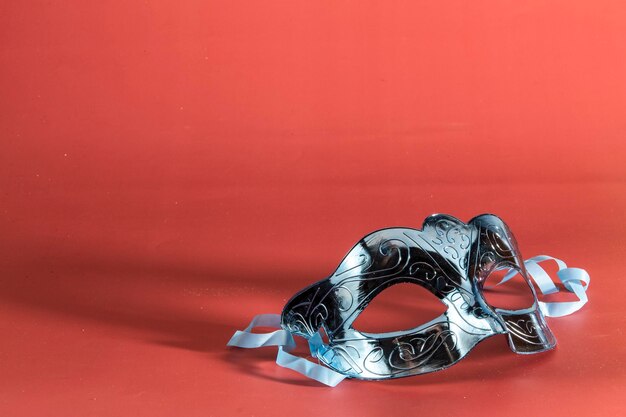Венецианская карнавальная маска, образующая рамку в одном из нижних углов с местом для текста