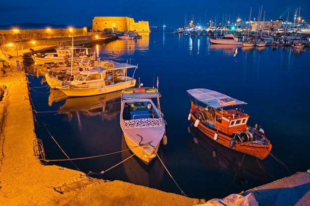 Photo venetian fort in heraklion and moored fishing boats crete island greece