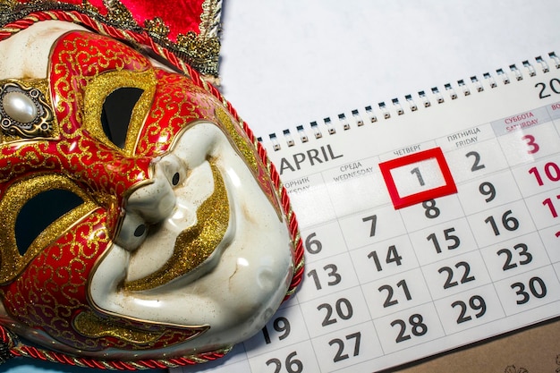 Venetian jester mask and calendar on a blue background concept photo for april 1 fools day holiday