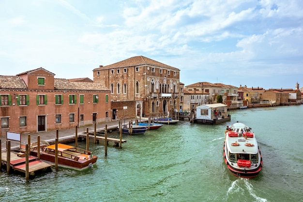 Venetian lagoon canal with parked boats in murano